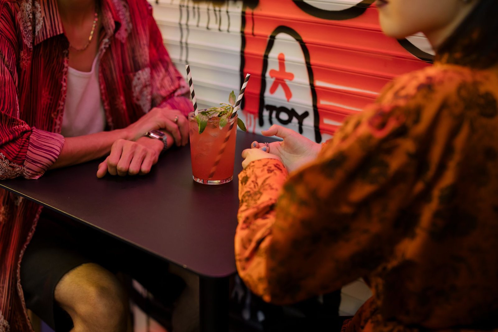 Two adults in relaxed conversation at an evening restaurant table