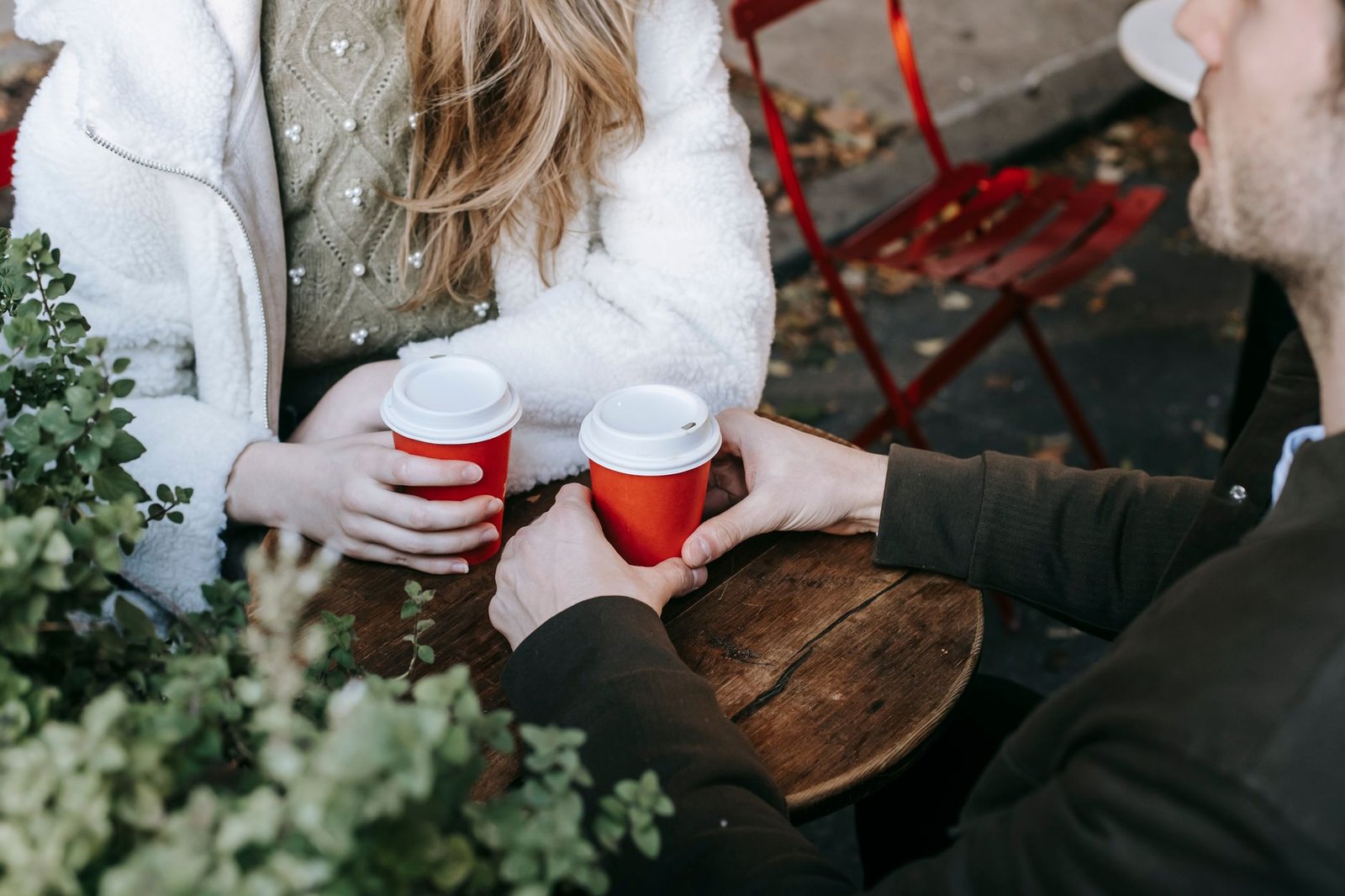 Two adults in relaxed conversation over drinks at a café table