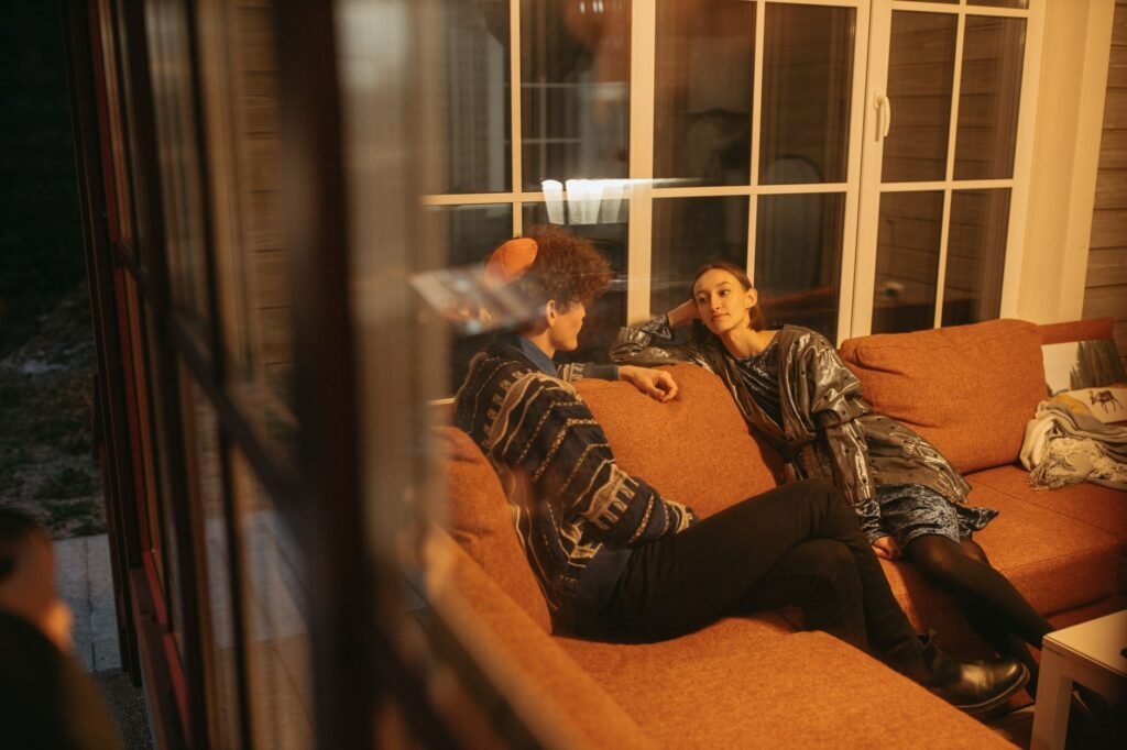 Two adults in quiet conversation at a warmly lit indoor table