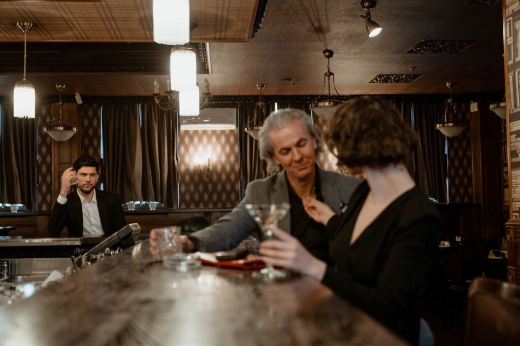 Two adults in quiet conversation at a table in a softly lit lounge