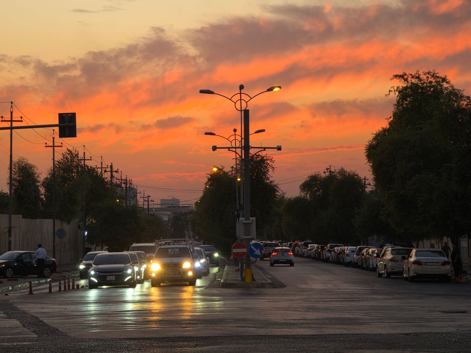 Quiet residential street in Abuja at dusk with warm streetlights