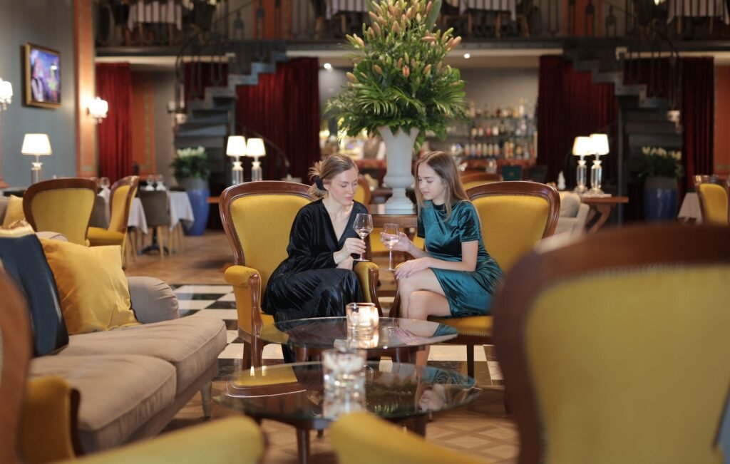 Two adults talking quietly in a modest hotel lounge in the evening