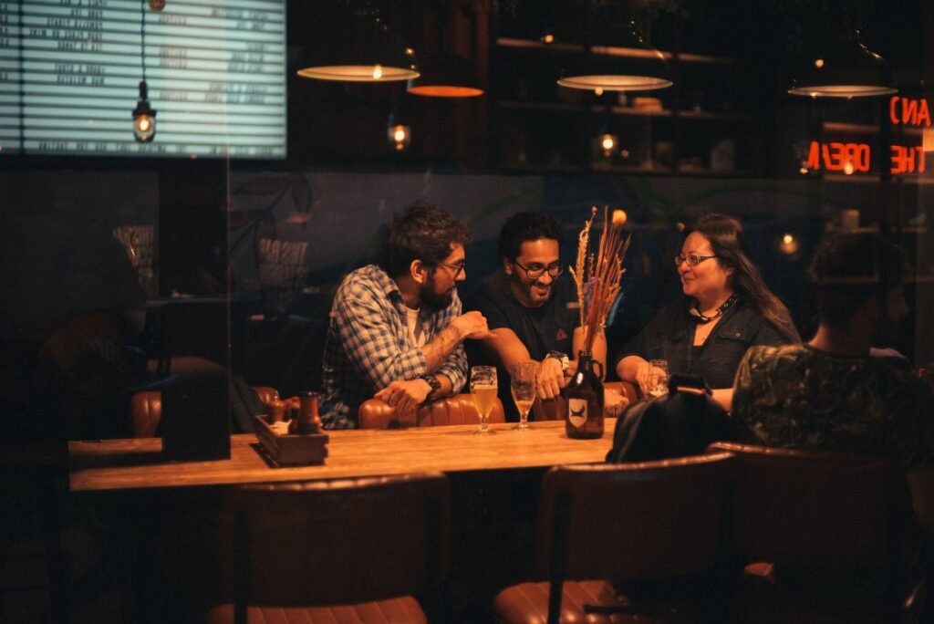 Adults talking over drinks in a warmly lit lounge in the evening