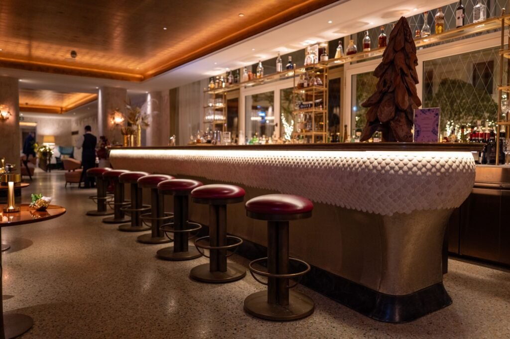 Warmly lit hotel lounge interior in a highland Nigerian town with armchairs