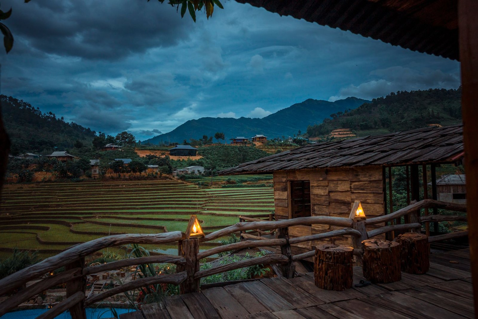 Quiet outdoor terrace bar in a highland Nigerian town at dusk with soft lighting