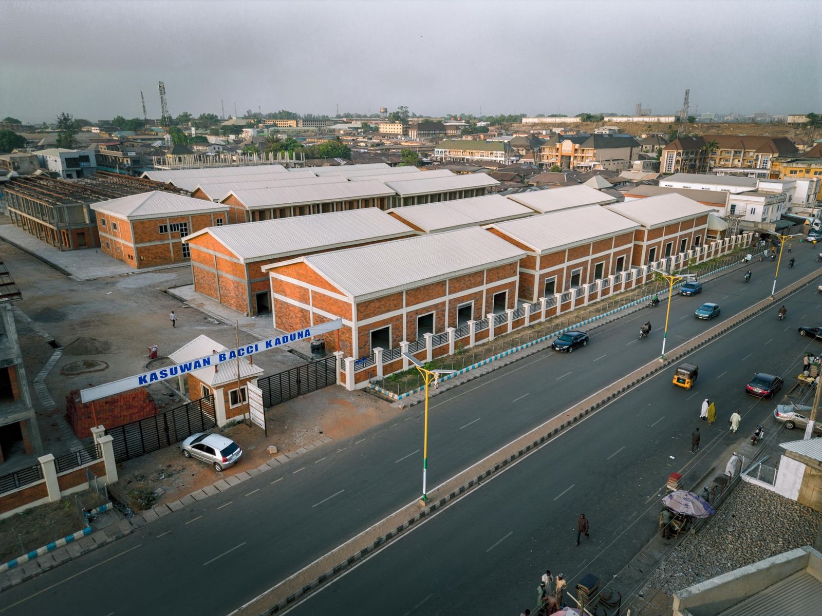 Quiet street in a Plateau State highland town at dusk, suggesting Angwan Rogo setting for a companion booking etiquette guide