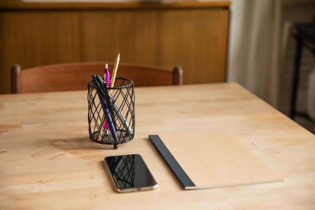 Notebook, pen and smartphone on a table, suggesting planning and clear communication before a booking