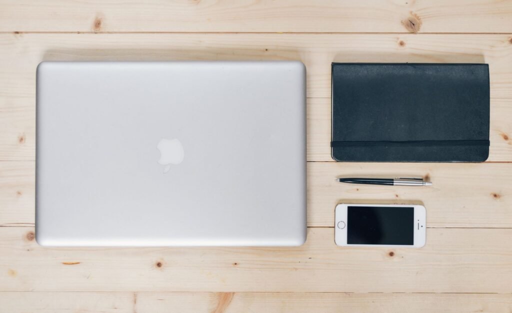 Smartphone and notebook on a wooden table in natural daylight