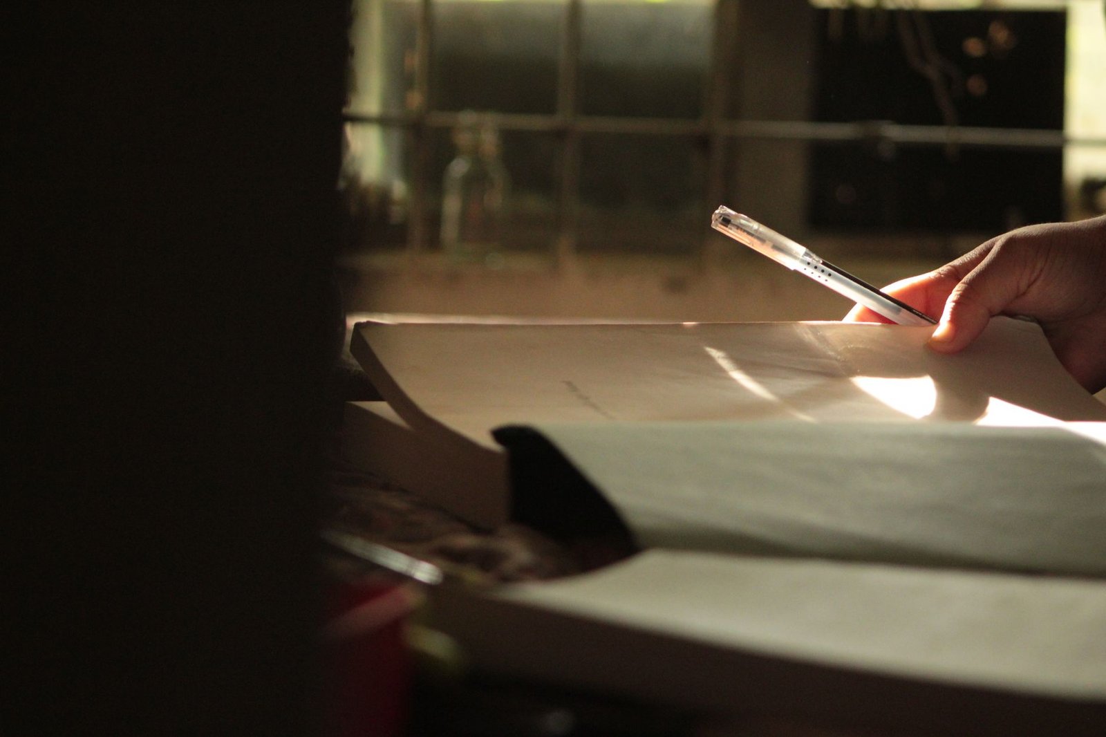 A quiet indoor table with a notebook and glass of water in soft afternoon light, representing careful booking planning