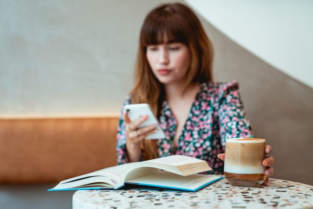 Person reading a website on a smartphone in a bright Lagos cafe