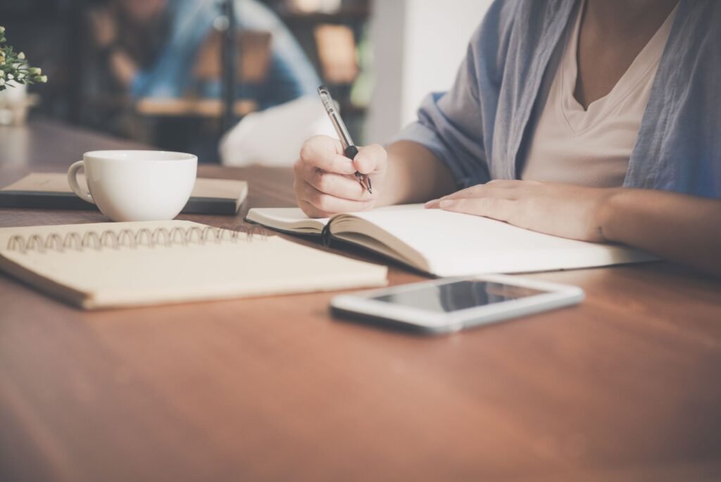 Person taking notes while browsing on a smartphone