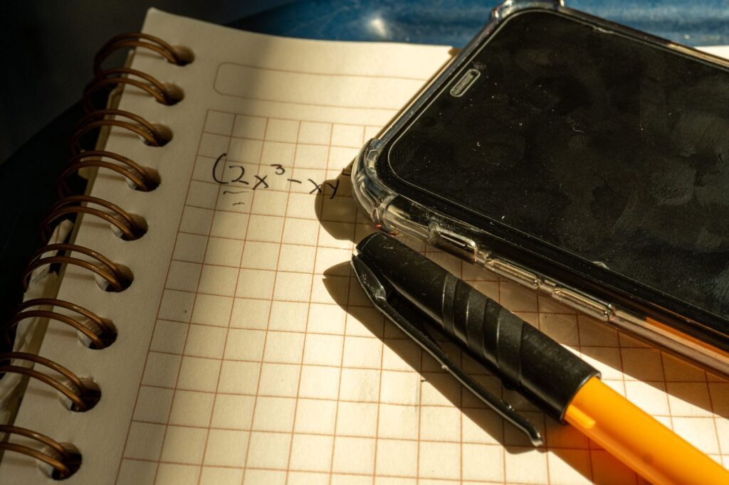 Smartphone and notebook on a wooden table in warm indoor light