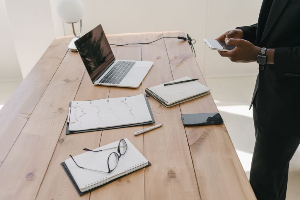 Smartphone on a table beside a notebook, suggesting careful profile browsing at home