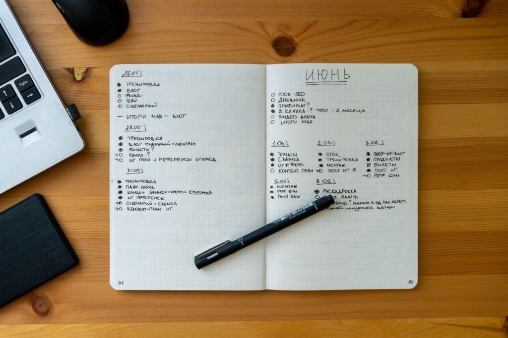 Notebook, pen and phone on a table for trip planning